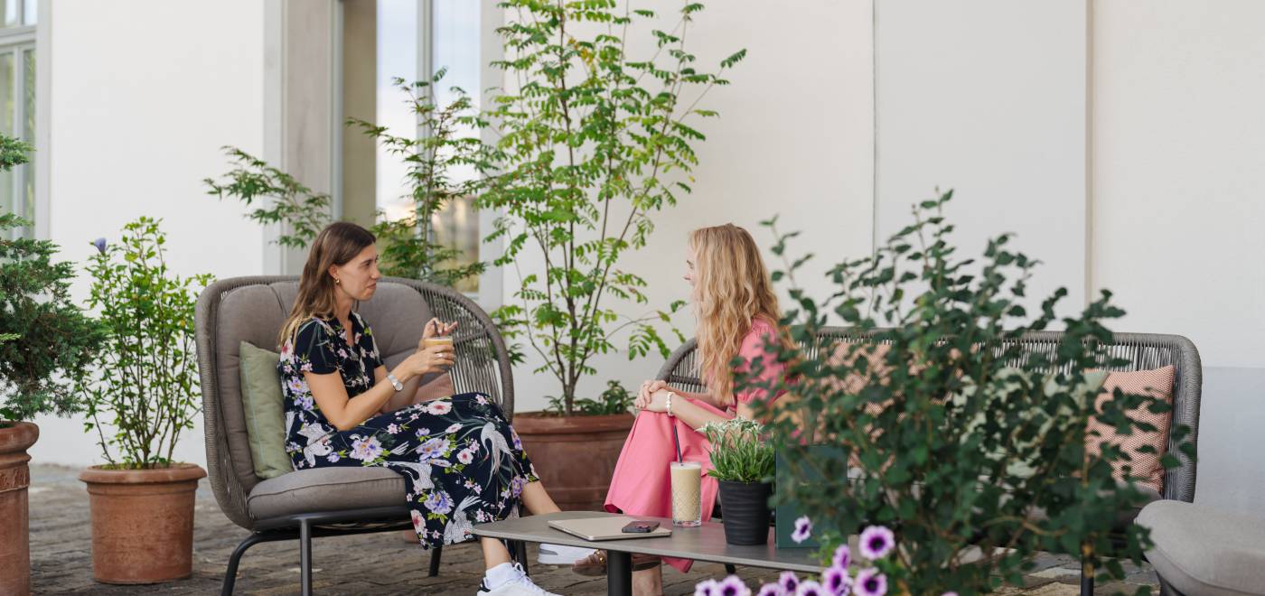 Two women enjoy a drink on the cosy terrace with its cobblestone floor