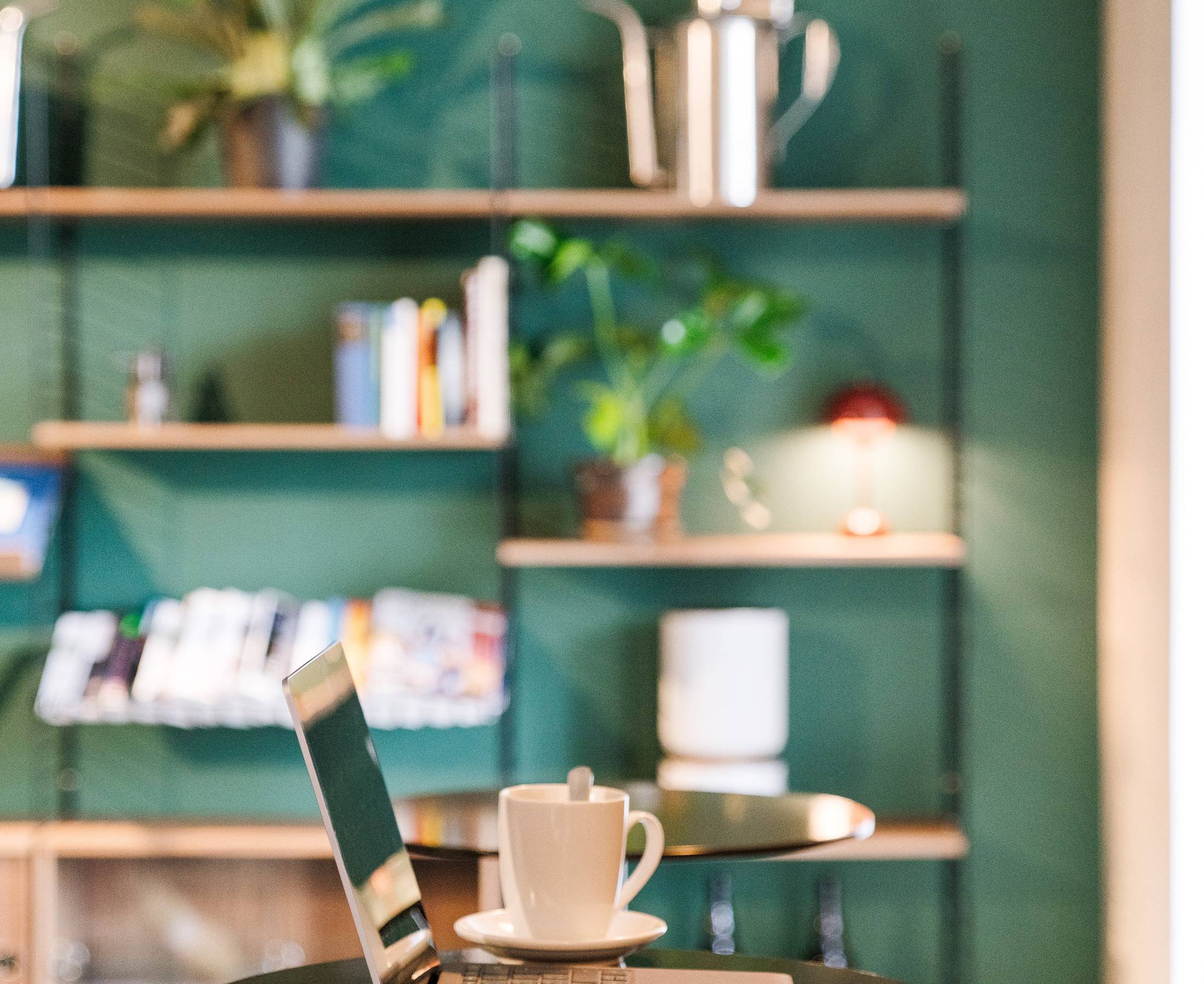 Ordinateur portable et café posés sur table dans l'espace de coworking du B2 Hotel 