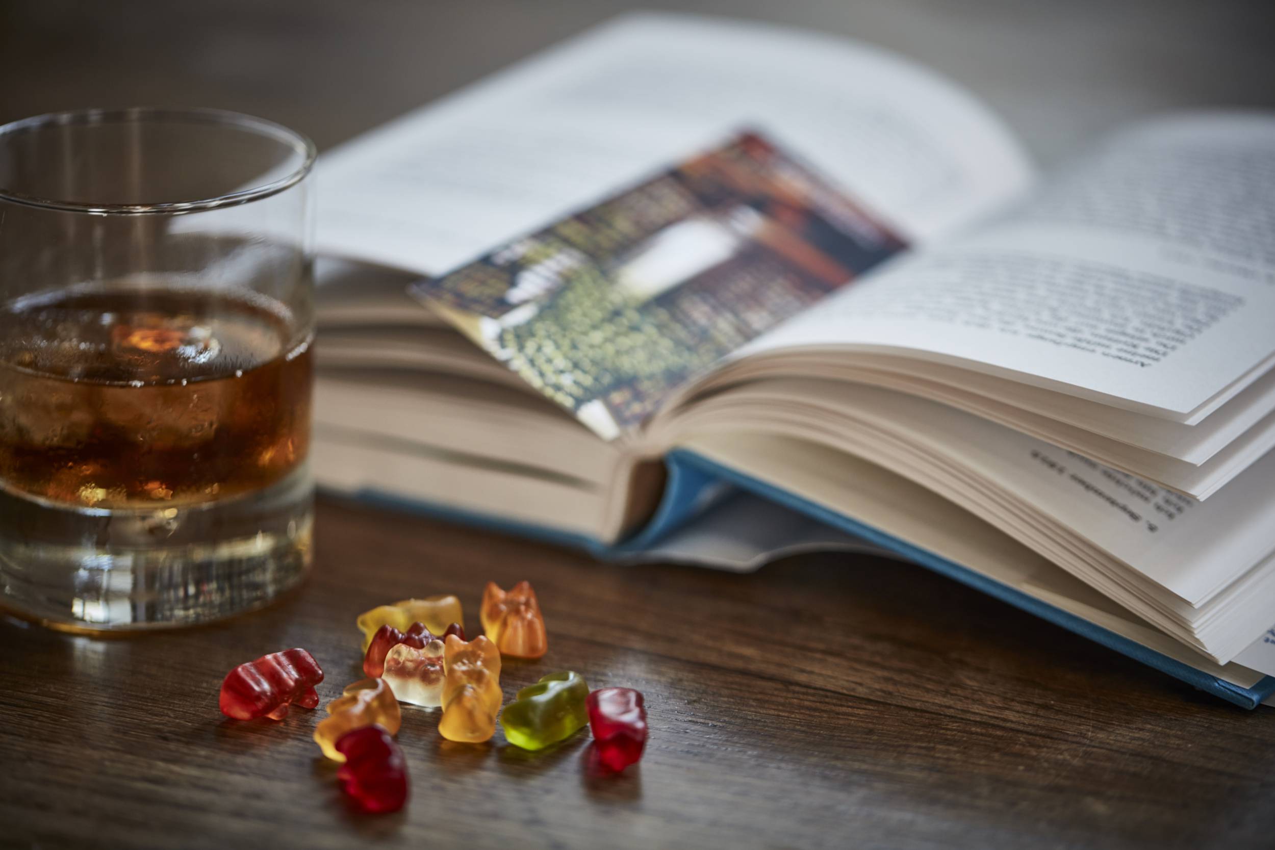 Getränk auf Tisch mit Buch und Gummibärchen