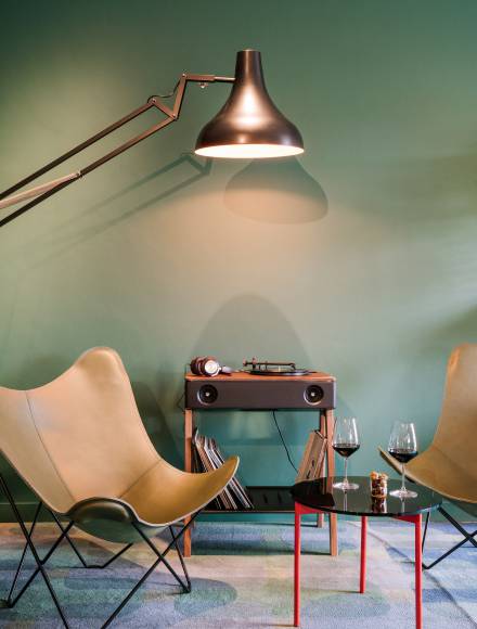 Old record player with comfortable armchairs and wine glasses on a coffee table in the B2 Hotel Zurich