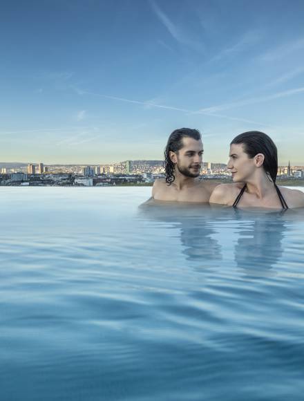 Couple enjoying the infinity roof top pool from the thermalbath in the center of Zurich
