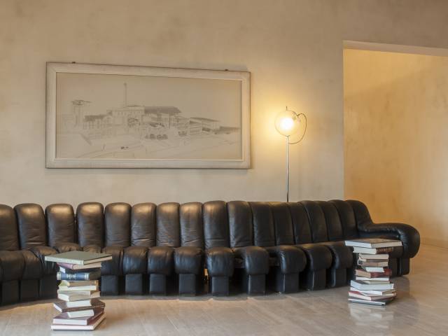 Sofa and stacked books in the lobby of the B2 Hotel