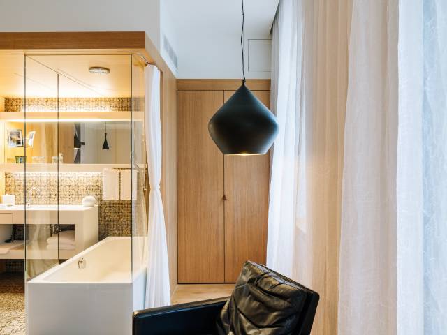 Baignoire de chambre et fauteuil confortable noire d'une chambre du B2 HĂ´tel de Zurich