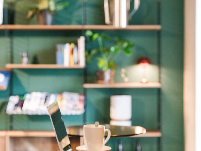 Ordinateur portable et café posés sur table dans l'espace de coworking du B2 Hotel