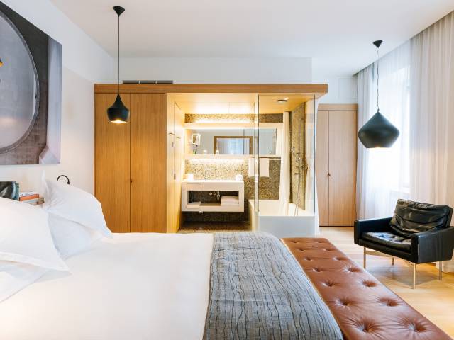 Vue sur chambre avec lit, salle de bain et baignoire du B2 Hotel Zürich